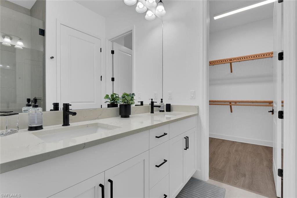 7242 Saona Court Naples, FL 34113 - Photo 14 of 34 a bathroom with a sink vanity granite and a mirror