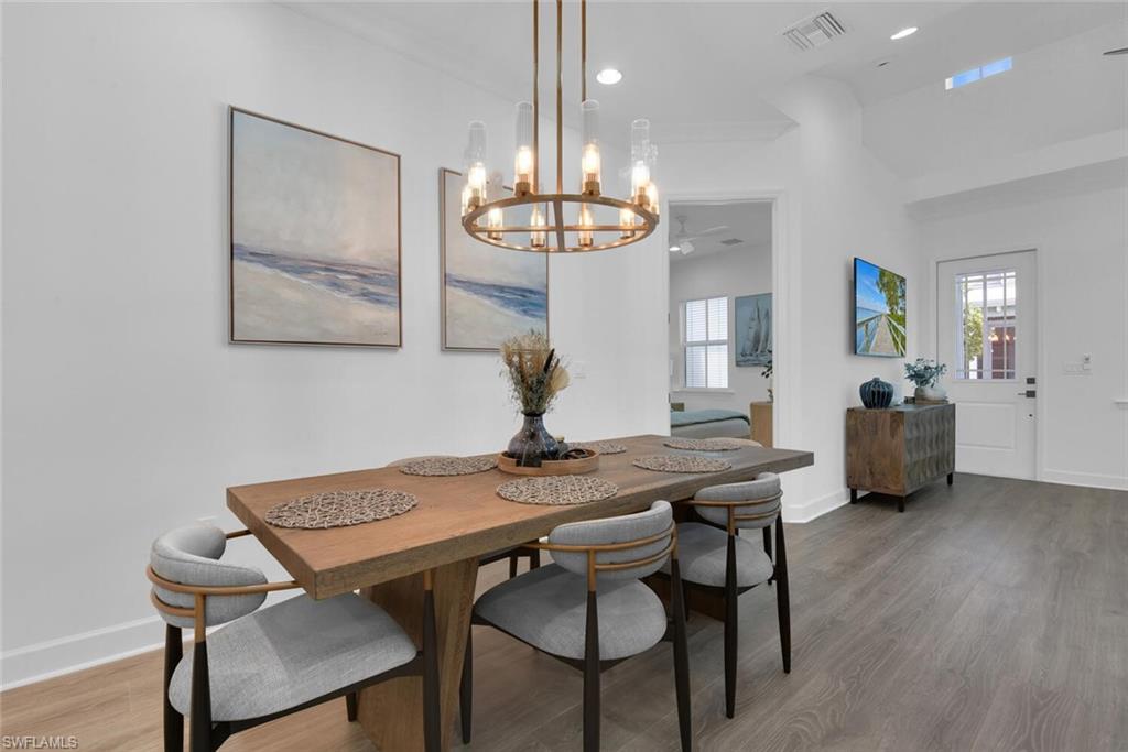 7242 Saona Court Naples, FL 34113 - Photo 7 of 34 a view of a dining room with furniture and chandelier