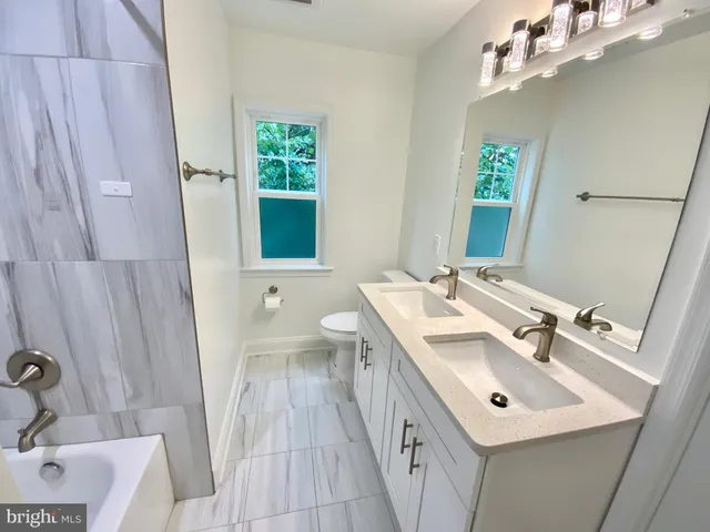 a bathroom with a sink a toilet and a mirror