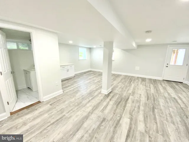 a view of a big room with wooden floor and windows