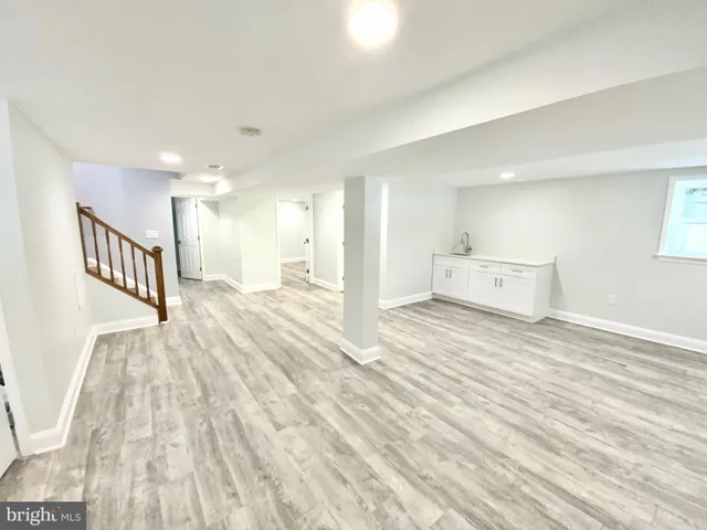 a view of a big room with wooden floor and windows