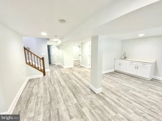 a view of a big room with wooden floor and windows