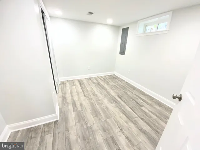 a view of empty room with wooden floor