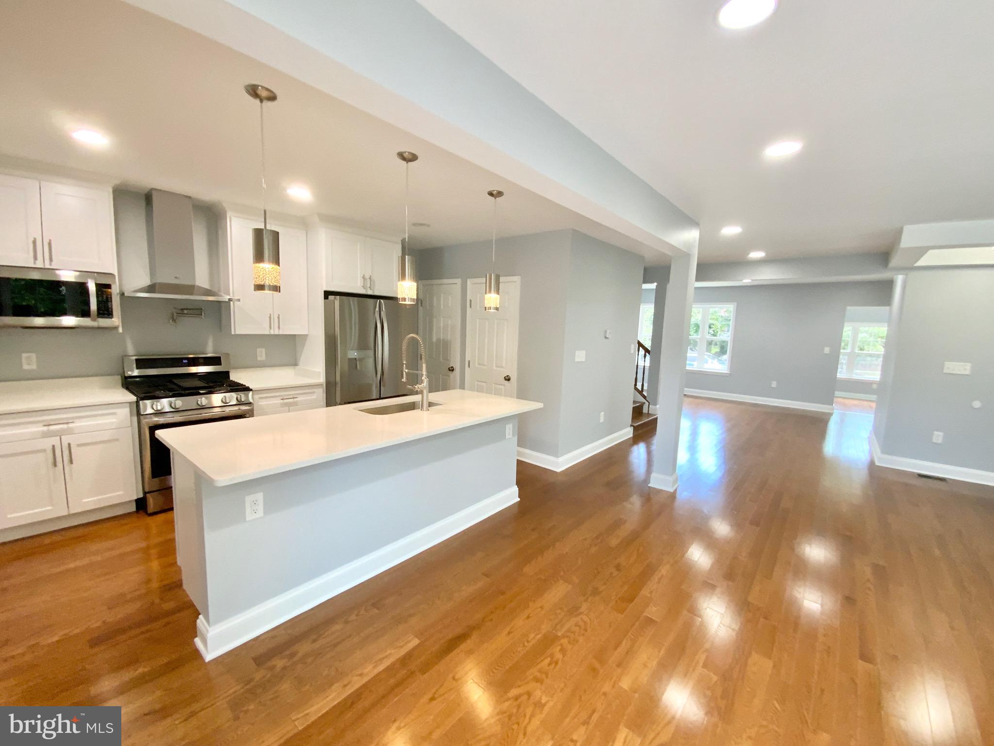 1318 Ingraham Street Northwest Washington, DC 20011 - Photo 5 of 35 a large kitchen with stainless steel appliances lots of counter space and wooden floor