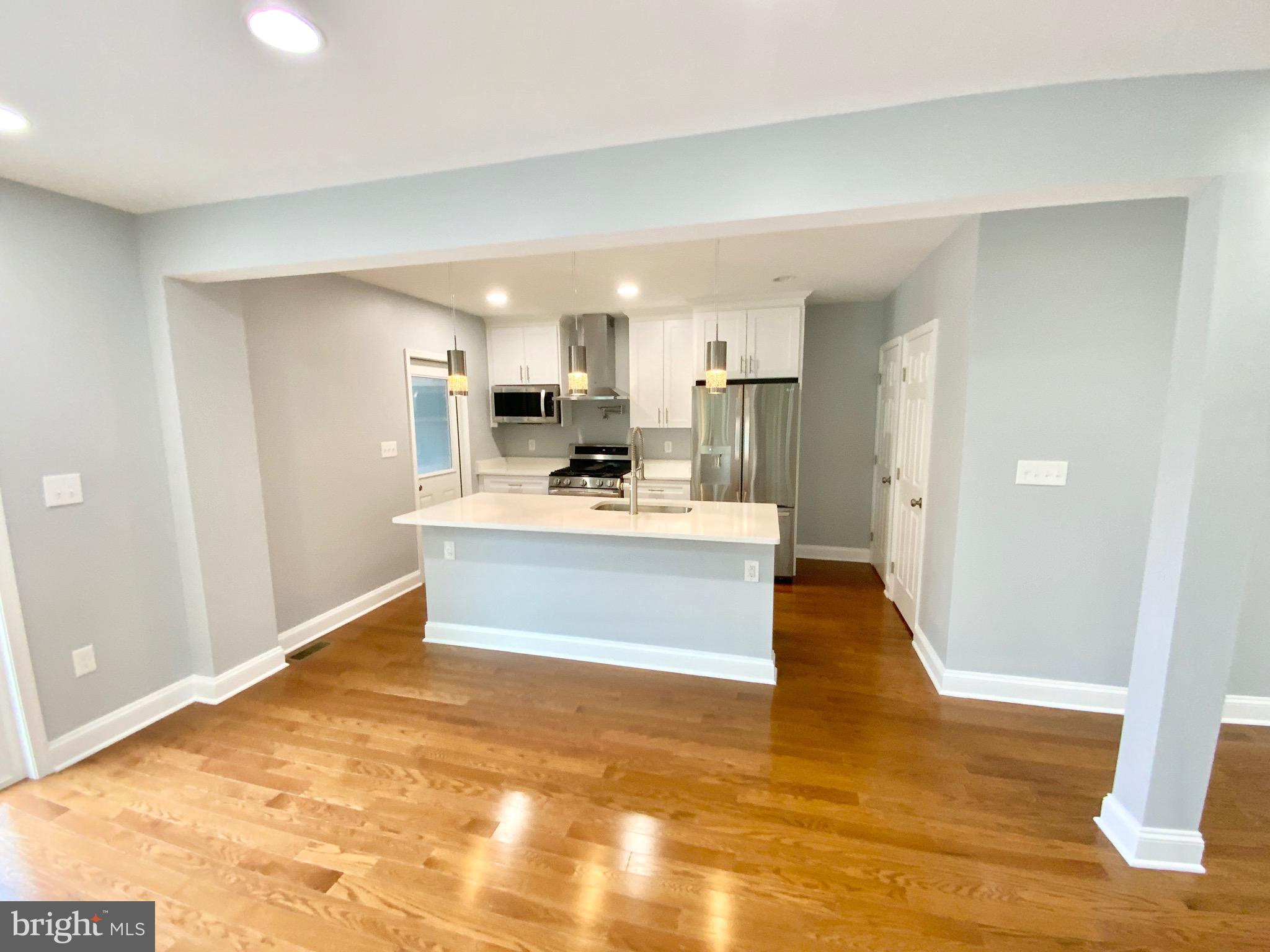 1318 Ingraham Street Northwest Washington, DC 20011 - Photo 6 of 35 a large kitchen with kitchen island a sink stainless steel appliances and cabinets