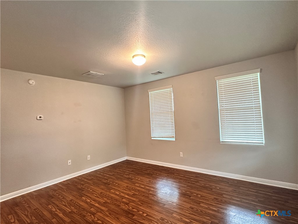 264 Trestle Tree, Unit A San Marcos, TX 78666 - Photo 17 of 17 an empty room with wooden floor and windows