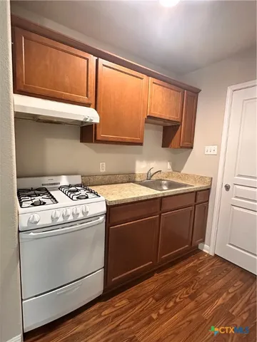 a kitchen with granite countertop cabinets stainless steel appliances and a sink