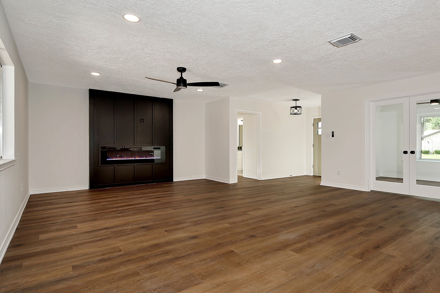 19410 Craigchester Lane Spring, TX 77388 - Photo 16 of 32 Open and spacious living room has a wood paneled feature wall with 5-foot electric fireplace. This dynamic wall adds dimension and anchors the space perfectly.