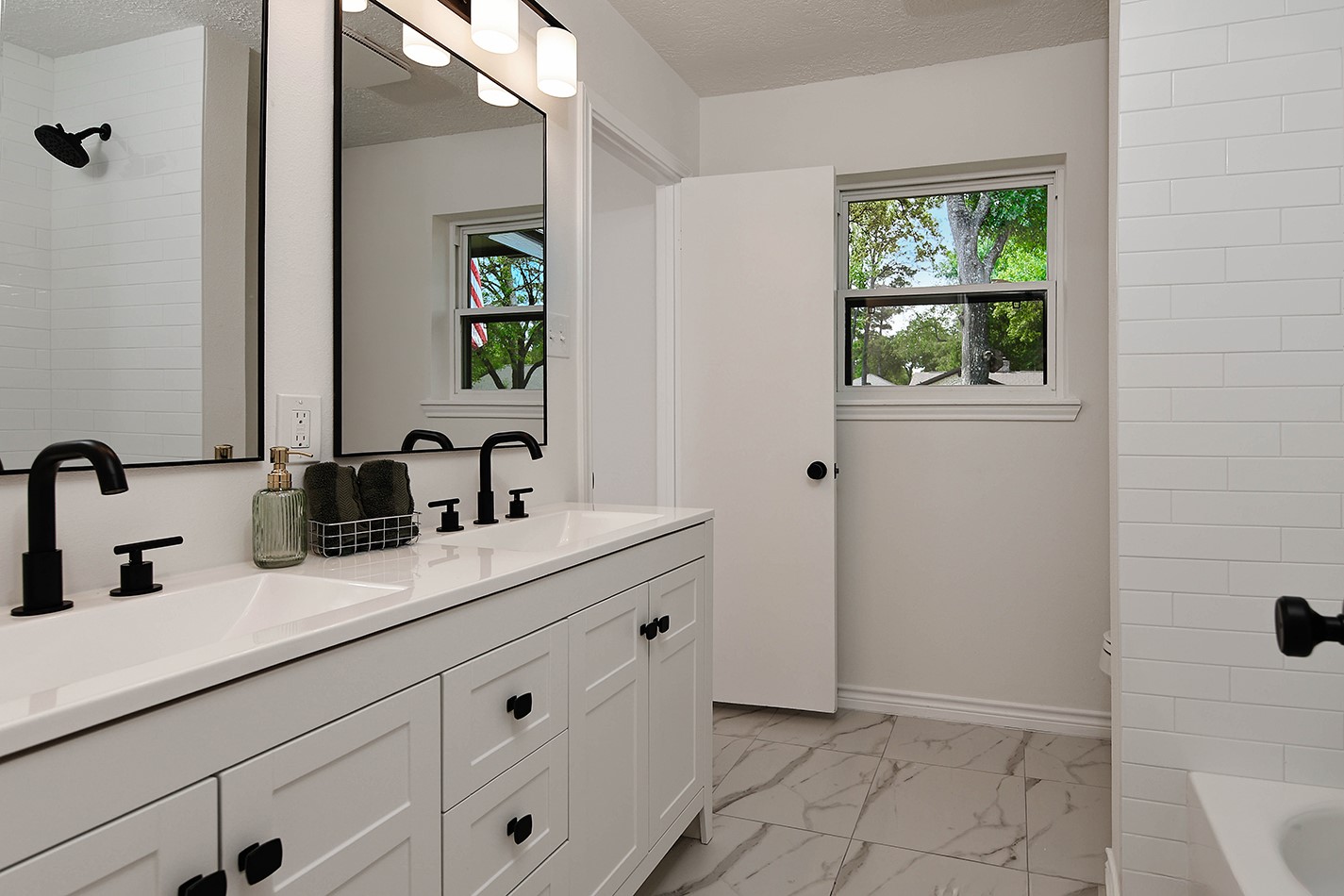 19410 Craigchester Lane Spring, TX 77388 - Photo 20 of 32 Bathroom 2 has direct access off main hallway for family and guests, as well as from Bedroom 2. Modern white with black looks striking and is on-trend. New tile floor and surround for tub/shower combination.