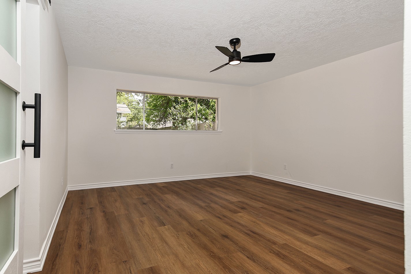 19410 Craigchester Lane Spring, TX 77388 - Photo 25 of 32 Primary bedroom has pleasing neutral paint color to go with any decor, new fan, and luxury vinyl wood plank flooring.