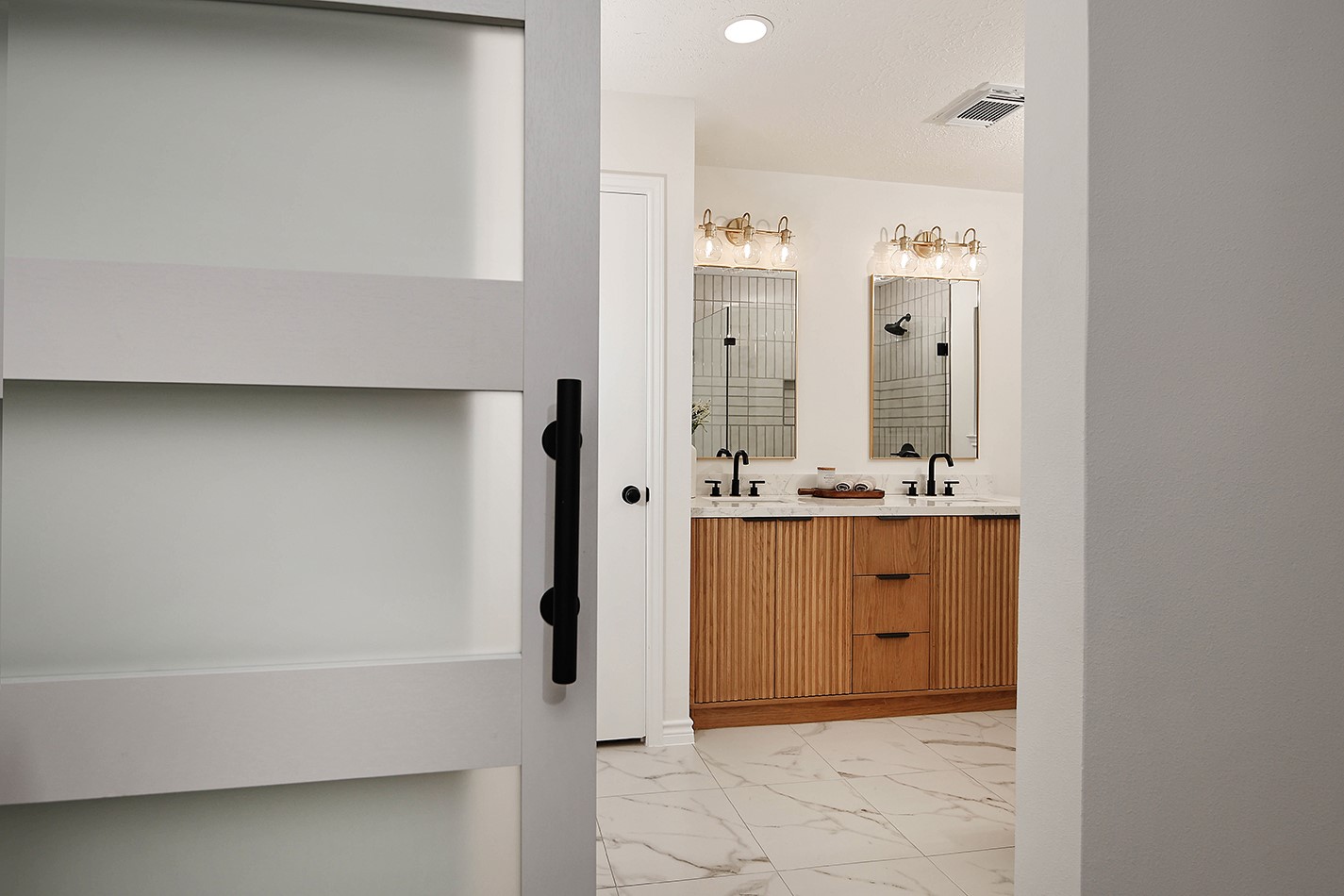19410 Craigchester Lane Spring, TX 77388 - Photo 27 of 32 Primary bedroom has a stylish ensuite bath separated by an unexpected new custom sliding barn door with 5-horizontal lites, adding an element of elevated design feature to room.