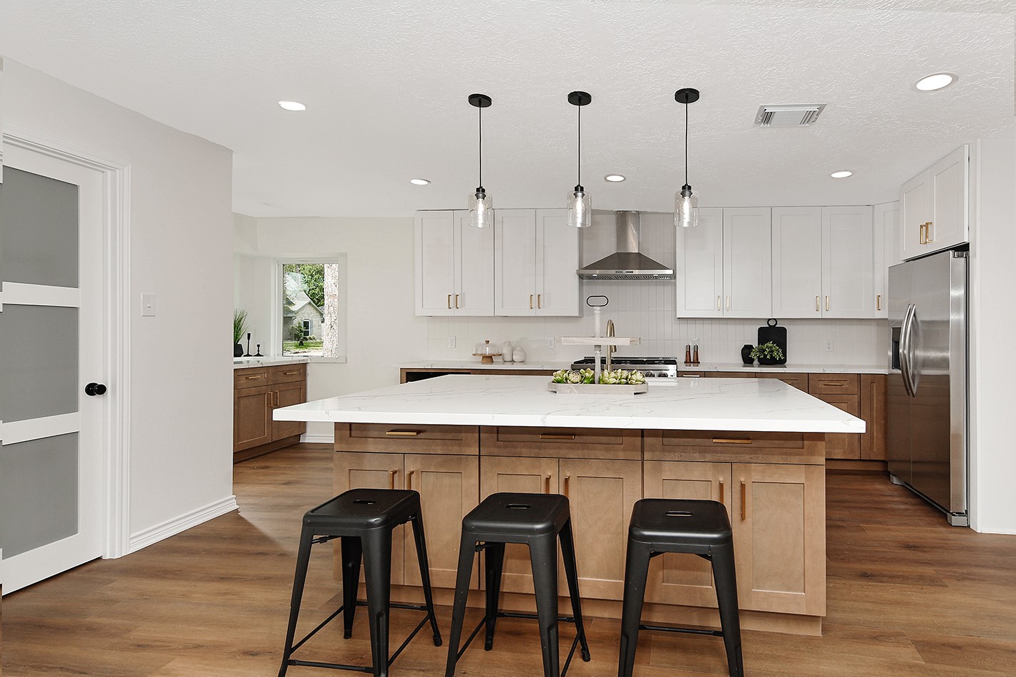 19410 Craigchester Lane Spring, TX 77388 - Photo 7 of 32 Magazine worthy kitchen has oversized central island in premium quartz with room for seating, incredible storage on both sides, and modern pendant lights.