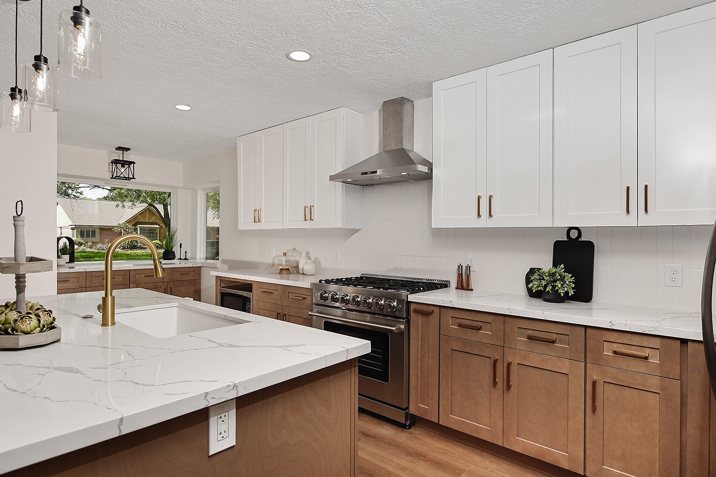 19410 Craigchester Lane Spring, TX 77388 - Photo 8 of 32 Upscale modern finishes and designer colors create an inviting atmosphere in kitchen. Custom cabinets in white uppers with stained wood bottoms are accented by beautiful linear gold pulls.