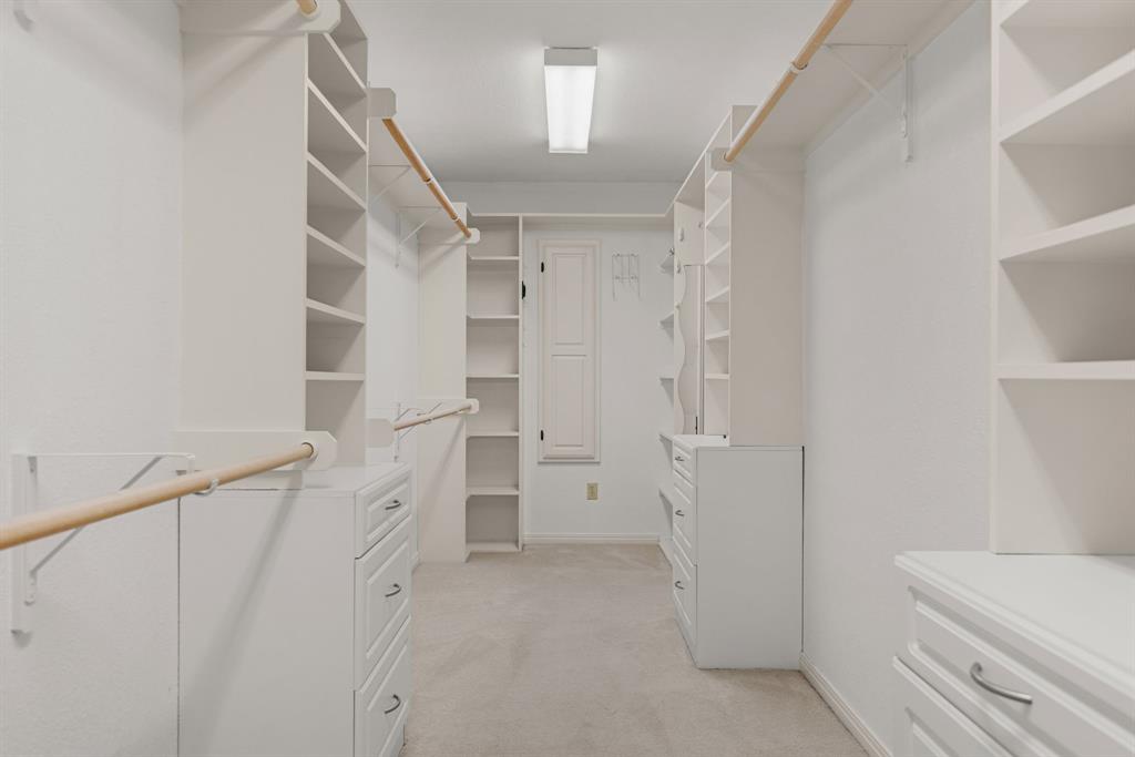 13539 Chapel Road Lorena, TX 76655 - Photo 16 of 37 Spacious walk-in closet featuring extensive built-in shelving, multiple hanging rods, integrated drawer units, and neutral carpeting