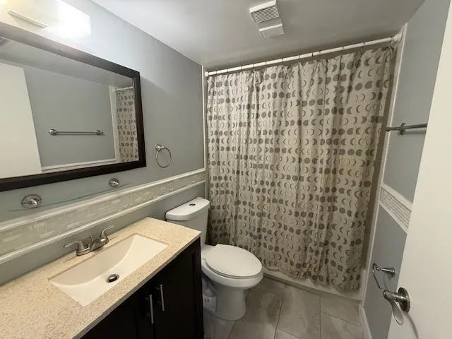 a bathroom with a sink a toilet and shower curtain