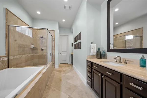 a spacious bathroom with a tub a sink and mirror
