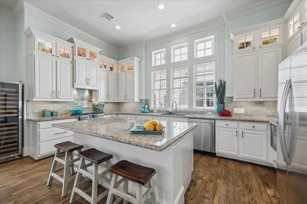 a kitchen with stainless steel appliances granite countertop a stove a sink and a refrigerator