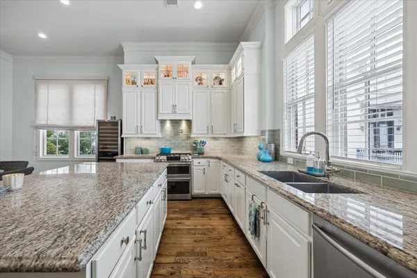 a large kitchen with stainless steel appliances granite countertop a lot of counter space and a sink