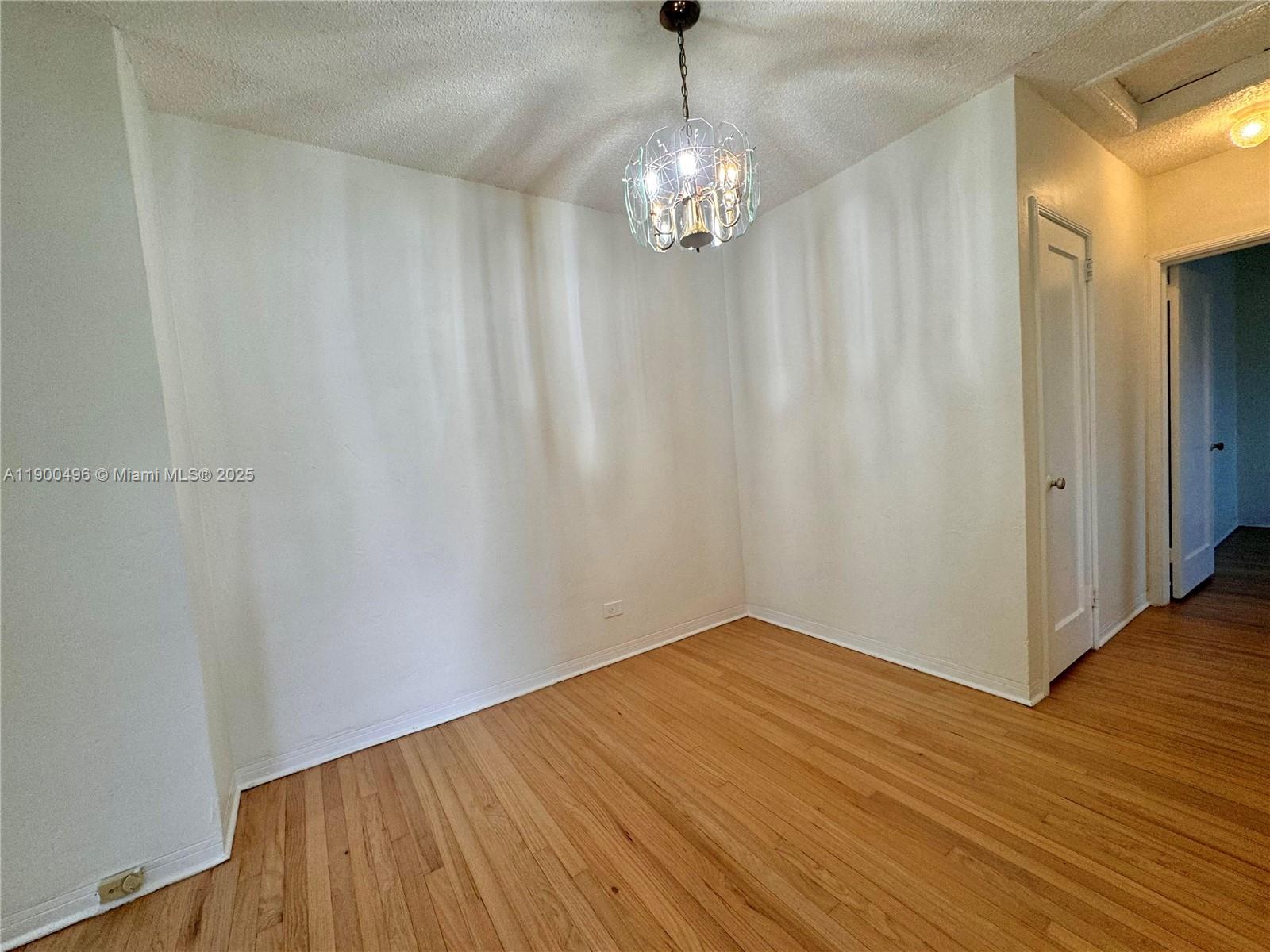 233 Northwest 45th Avenue, Unit 233 Miami, FL 33126 - Photo 4 of 11 a view of a hallway with wooden floor and chandelier