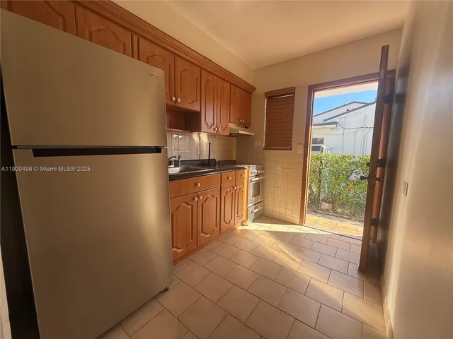 a kitchen with stainless steel appliances a refrigerator and a cabinets