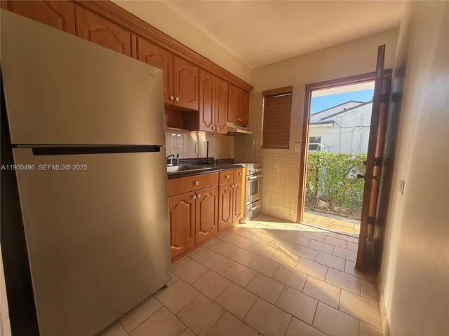 a kitchen with stainless steel appliances a refrigerator and a cabinets
