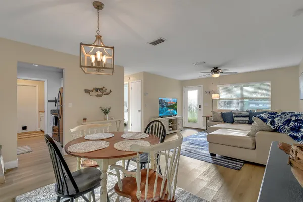 a living room with furniture a dining table and a chandelier