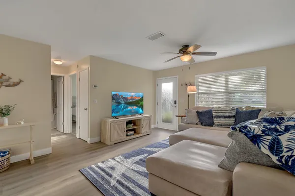a living room with furniture a flat screen tv and a large window