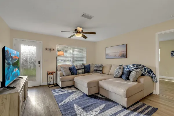 a living room with furniture a flat screen tv and a window