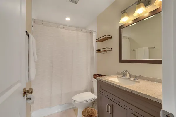 a bathroom with a granite countertop sink toilet and shower