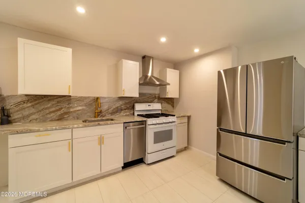 a kitchen with stainless steel appliances granite countertop a refrigerator sink and stove