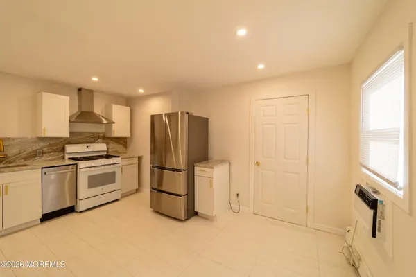 a kitchen with a refrigerator and a stove top oven
