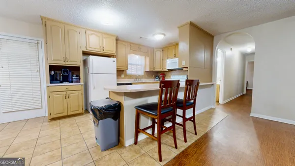 a dining room with furniture and a kitchen view