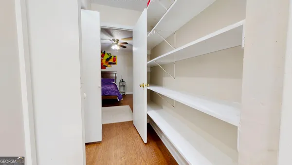 a view of walk in closet with clothes and shoes