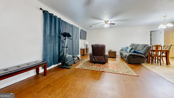 a living room with furniture gym equipment and a flat screen tv