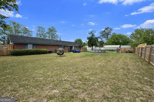 a view of a house with swimming pool and a yard