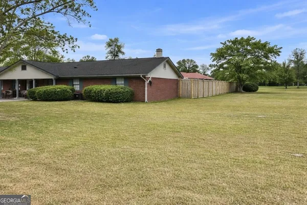 a view of a house with a yard and potted plants