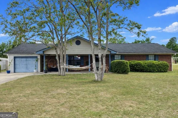 a view of a house with a yard and a tree