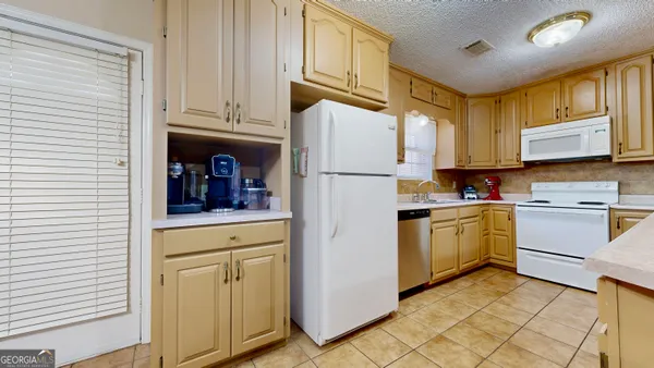 a kitchen with cabinets stainless steel appliances and sink