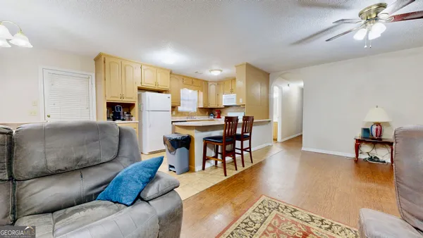 a living room with furniture and a dining table with kitchen view
