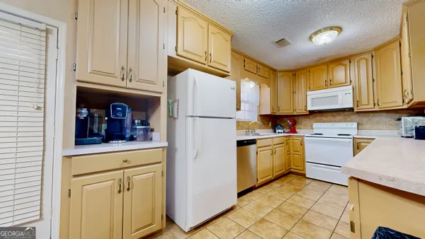 a kitchen with a refrigerator sink and cabinets