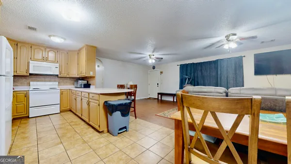 a kitchen with a table chairs sink and cabinets