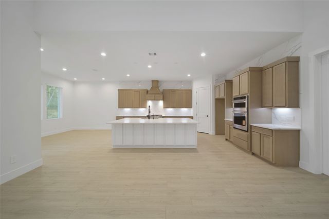 a large kitchen with a large counter top stainless steel appliances and cabinets