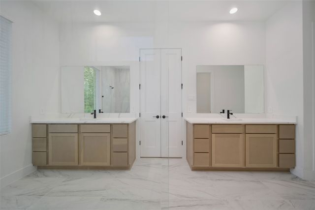 a bathroom with a double vanity sink a toilet and shower