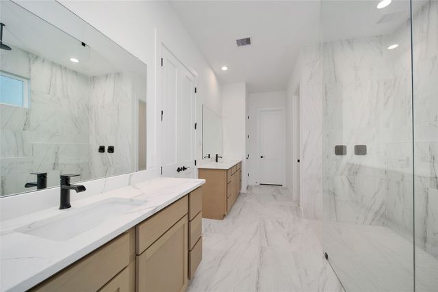 a bathroom with a double vanity sink mirror and shower