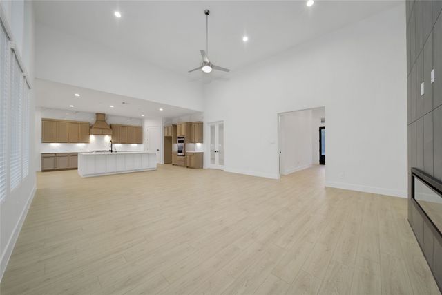 an empty room with kitchen view and living room