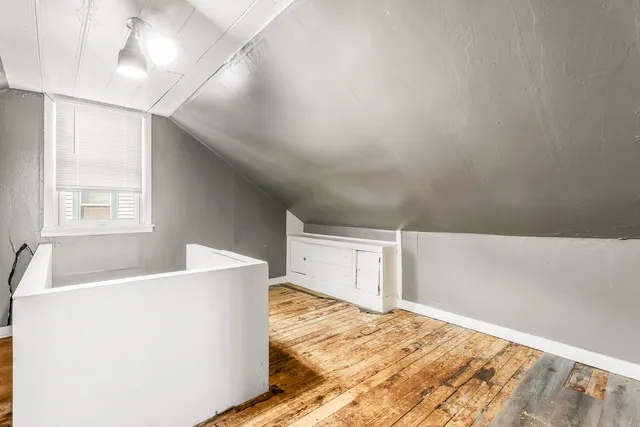 a bedroom with bed and wooden floor
