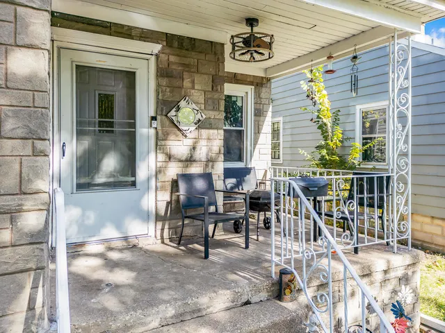 a view of a porch with chairs and potted plants