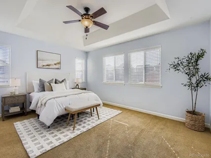 a spacious bedroom with a bed a chandelier and a window
