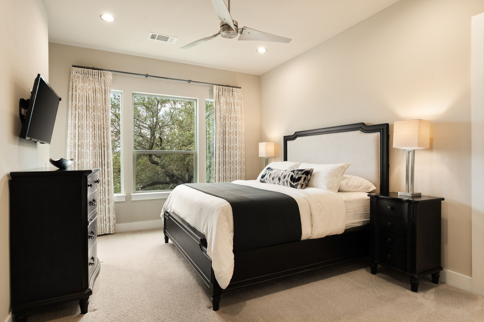 8110 Ranch Road 2222, Unit 81 Austin, TX 78730 - Photo 15 of 28 a bedroom with a bed and a flat tv screen on dresser