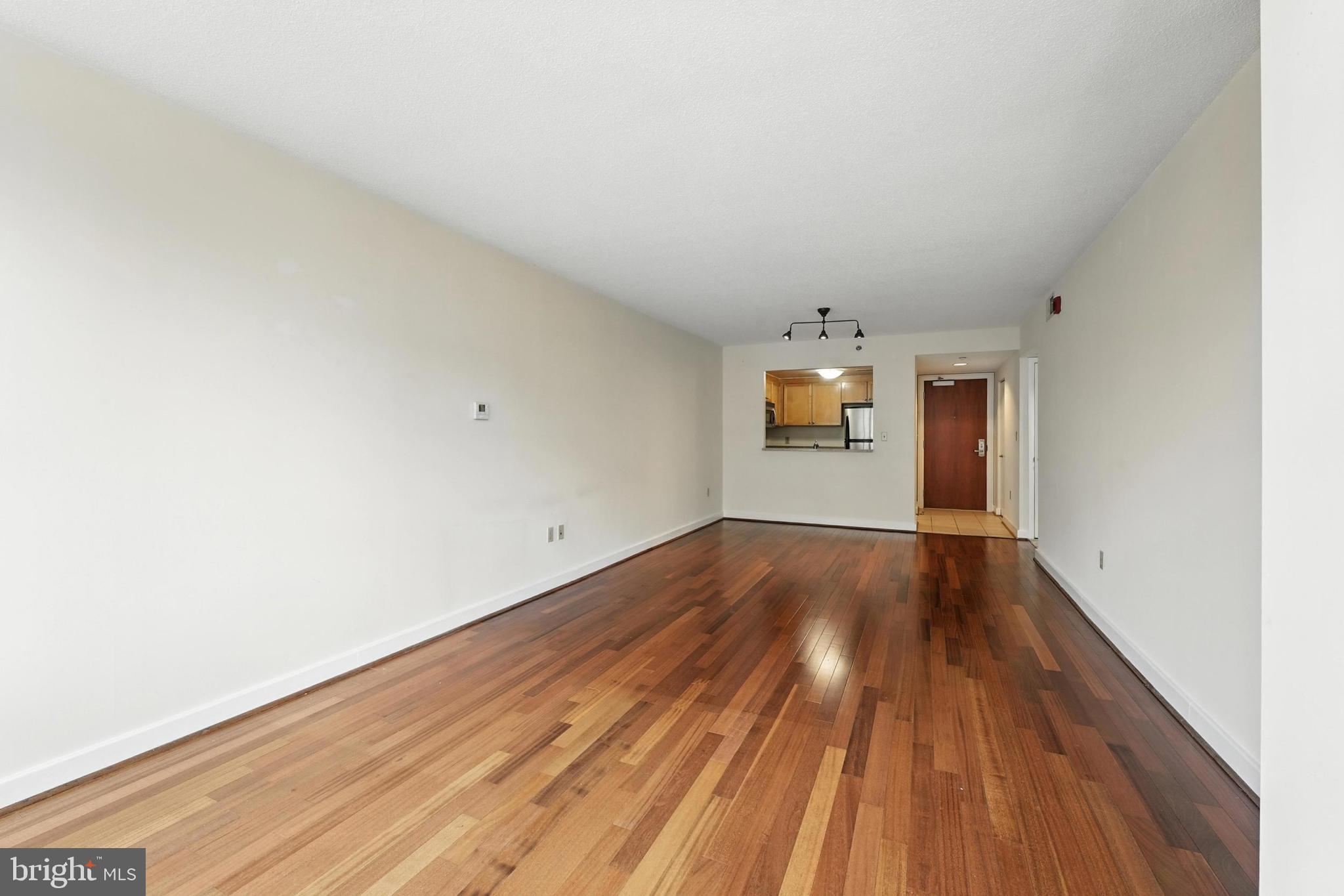 1150 K Street Northwest, Unit 1207 Washington, DC 20005 - Photo 13 of 29 a view of empty room with wooden floor and fireplace